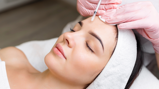 Woman receiving Botox injection for forehead wrinkle treatment